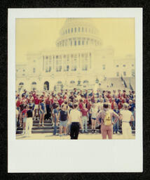 Photograph of the San Francisco Gay Men's Chorus performing on the steps of the Capitol Building in Washington D.C. as part of their 1981 National Tour. This photograph comes from a photo album belonging to Bill Graham, an early member of the Chorus. 