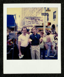 Photograph of two chorus members standing in front of the marquee at the Beacon Theatre during their 1981 National Tour. This photograph is from a photo album belonging to Bill Graham, an early member of the Chorus. 