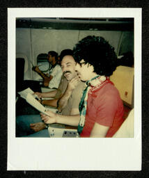 Photograph of chorus members on plane during their 1981 National Tour. This photograph comes from a photo album belonging to Bill Graham, an early member of the Chorus. 