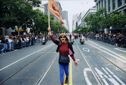 Victoria Schneider marches in a Pride parade with a sign for the sex workers' organization COYOTE (Call Off Your Old Tired Ethics).