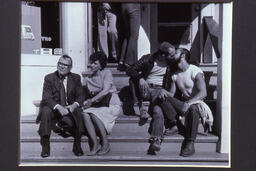 Crawford Barton photograph of two couples, a middle-aged straight couple and a young gay couple, on Castro Street steps. The gay couple are kissing.